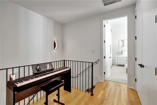 a view of a hallway with wooden floor and staircase