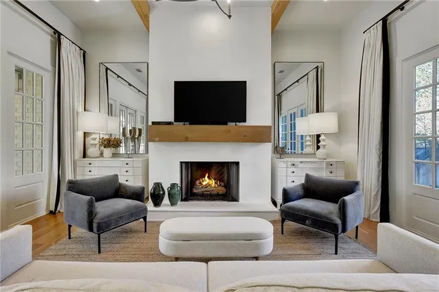 a living room with furniture a flat screen tv and a fireplace