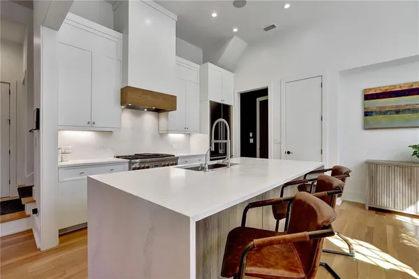 a kitchen with a stove a refrigerator and a dining table with wooden floor