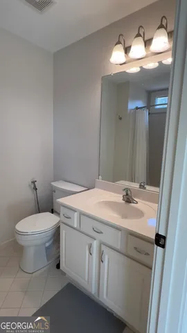 a bathroom with a toilet sink and mirror