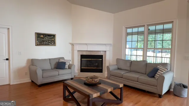 a living room with furniture a fireplace and wooden floor