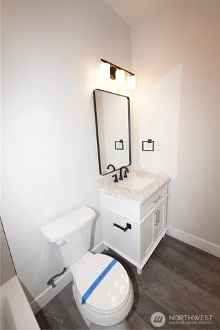 a view of hallway with window and wooden floor