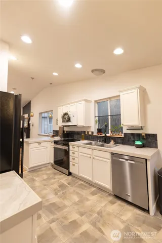 a kitchen with a refrigerator and a stove top oven