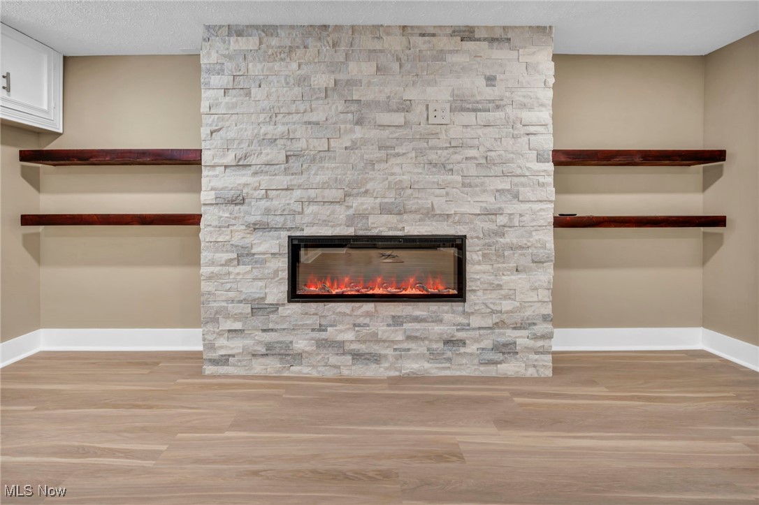 1447 East Sprague Road Independence, OH 44131 - Photo 38 of 47 Details featuring wood-type flooring, a textured ceiling, and a fireplace