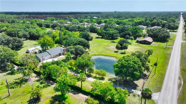 an aerial view of a house with a yard and lake view