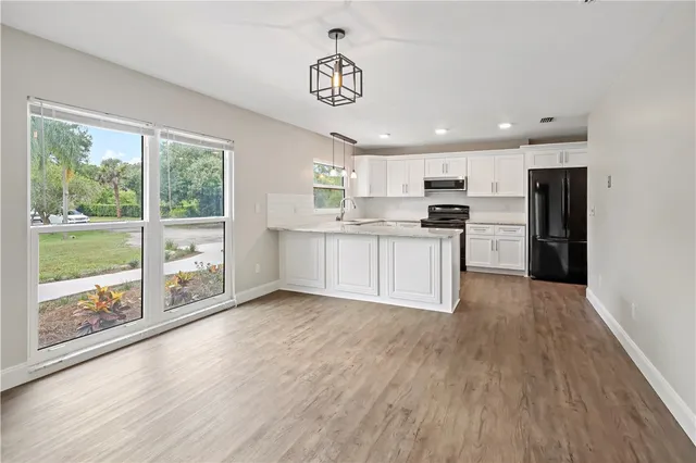 a kitchen with stainless steel appliances granite countertop a stove and a wooden floors