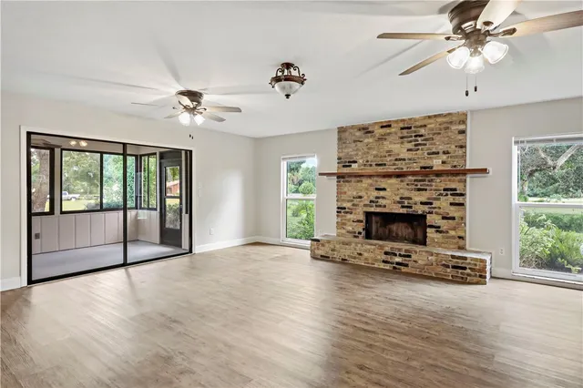 a view of an empty room with a fireplace and a window