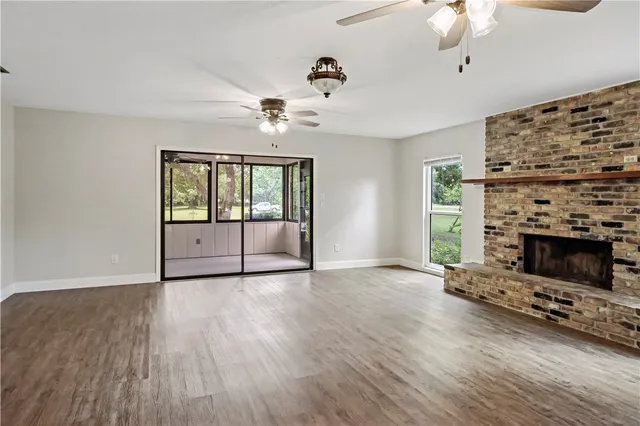 a view of an empty room with a fireplace and a window