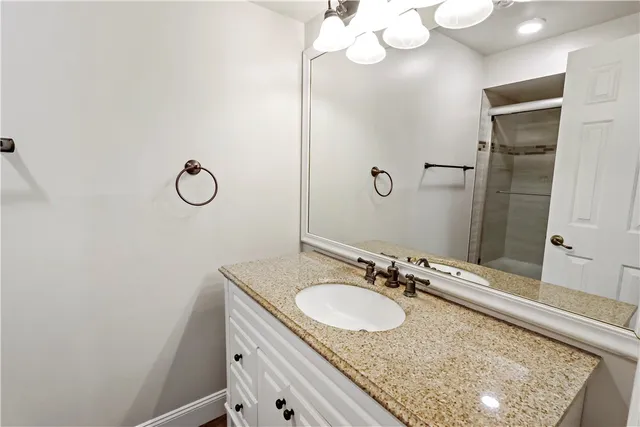 a bathroom with a granite countertop sink and a mirror