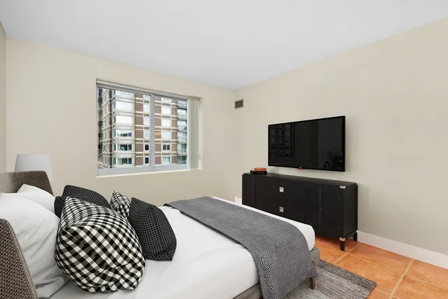 a bedroom with a bed and a flat screen tv