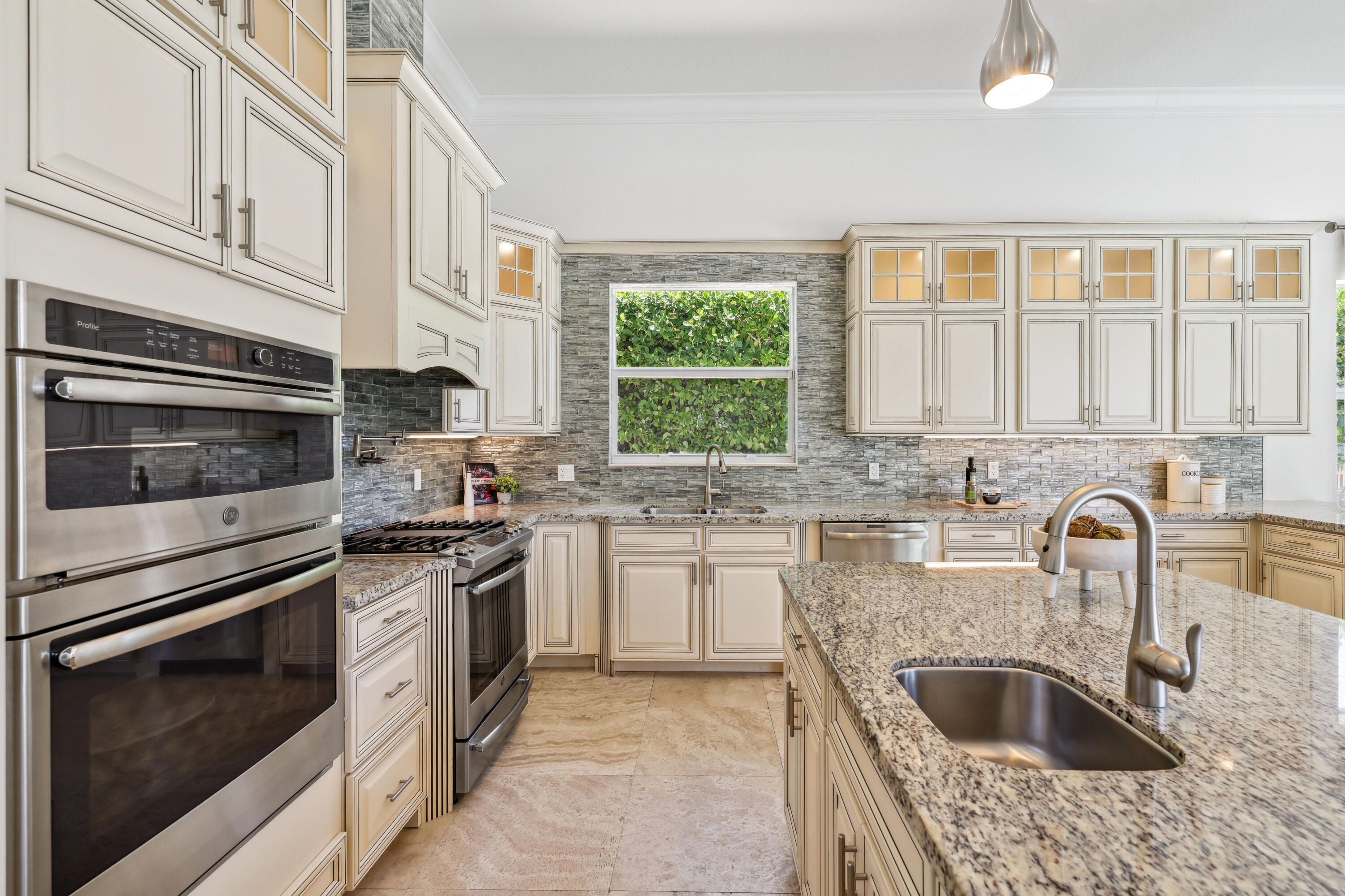 1030 Rhodes Villa Avenue Delray Beach, FL 33483 - Photo 15 of 76 a kitchen with granite countertop a stove sink and microwave
