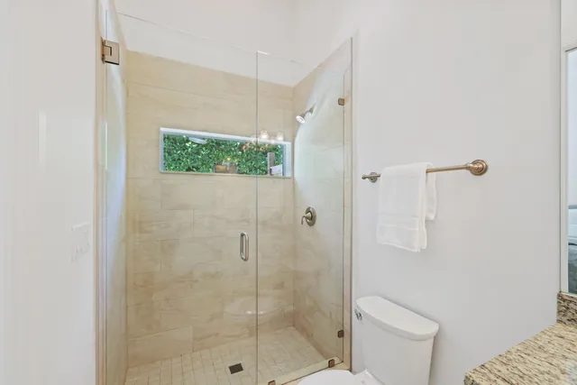 a bathroom with a granite countertop sink a mirror a bathtub and shower