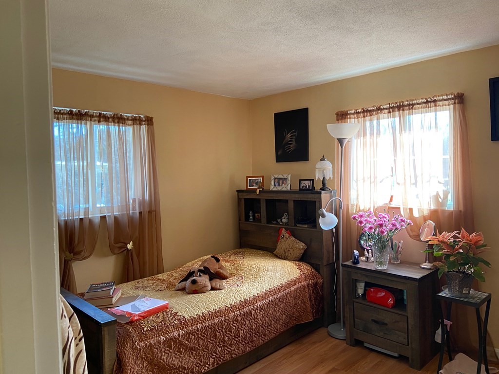 14 Bryon Road, Unit 3 Boston, MA 02467 - Photo 6 of 9 a bedroom with a bed table chair and a window