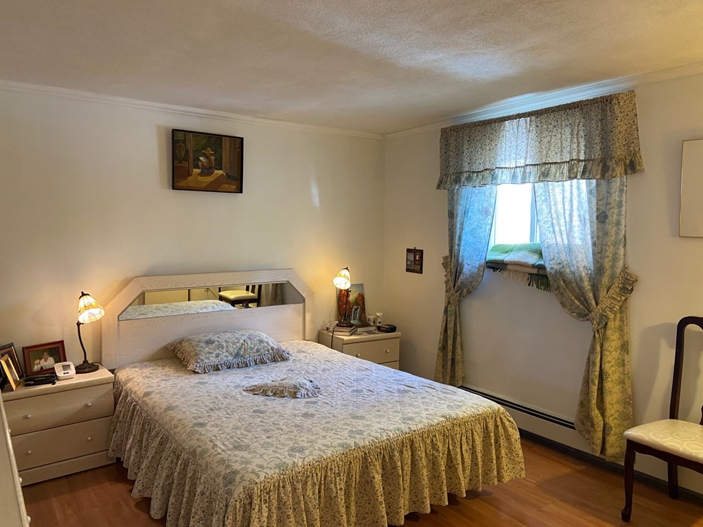 14 Bryon Road, Unit 3 Boston, MA 02467 - Photo 7 of 9 a bedroom with a bed and a lamp