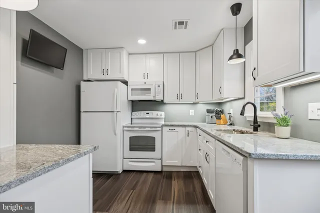 a kitchen with sink a refrigerator and cabinets