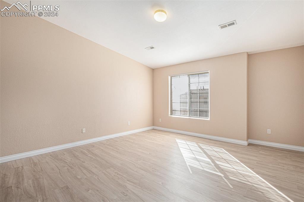 4822 Rusty Nail Point, Unit 201 Colorado Springs, CO 80916 - Photo 16 of 33 a view of an empty room with wooden floor and a window