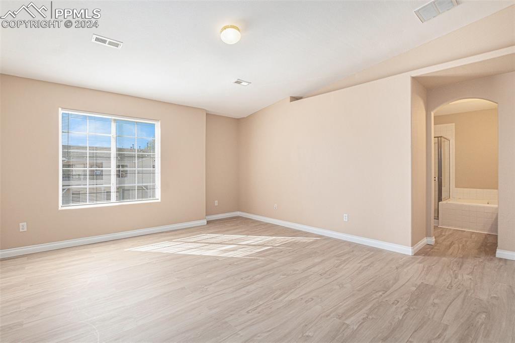 4822 Rusty Nail Point, Unit 201 Colorado Springs, CO 80916 - Photo 17 of 33 an empty room with wooden floor and windows