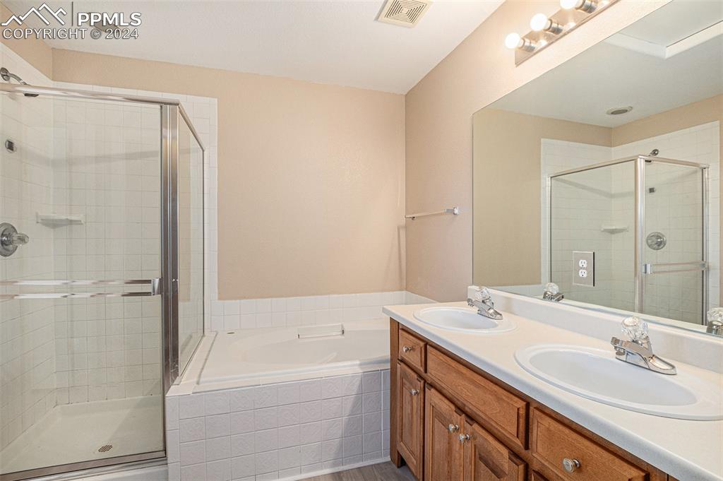 4822 Rusty Nail Point, Unit 201 Colorado Springs, CO 80916 - Photo 18 of 33 a bathroom with a tub sink shower and mirror