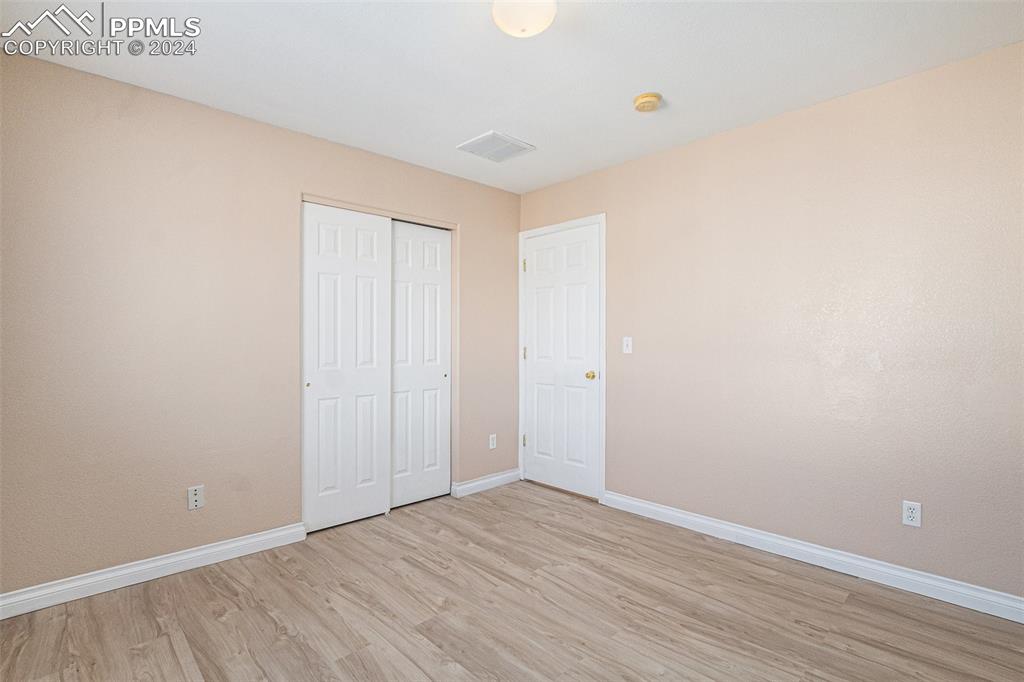 4822 Rusty Nail Point, Unit 201 Colorado Springs, CO 80916 - Photo 25 of 33 a view of an empty room with wooden floor