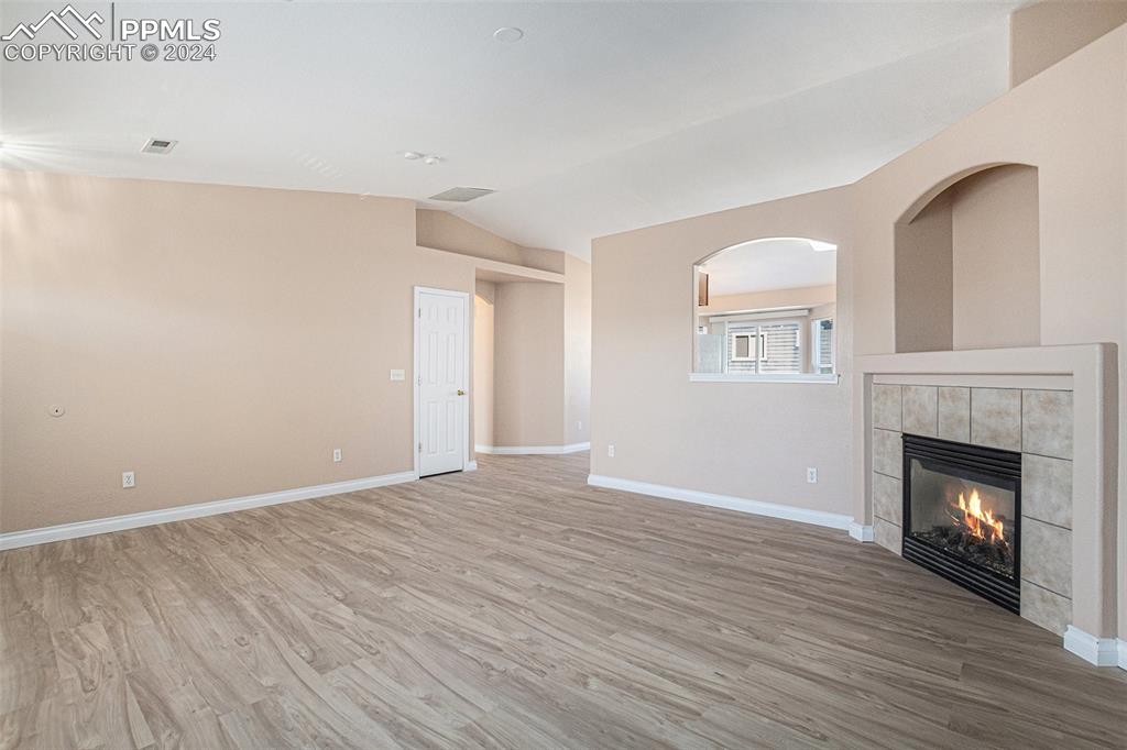 4822 Rusty Nail Point, Unit 201 Colorado Springs, CO 80916 - Photo 4 of 33 a view of an empty room with wooden floor fireplace and a window