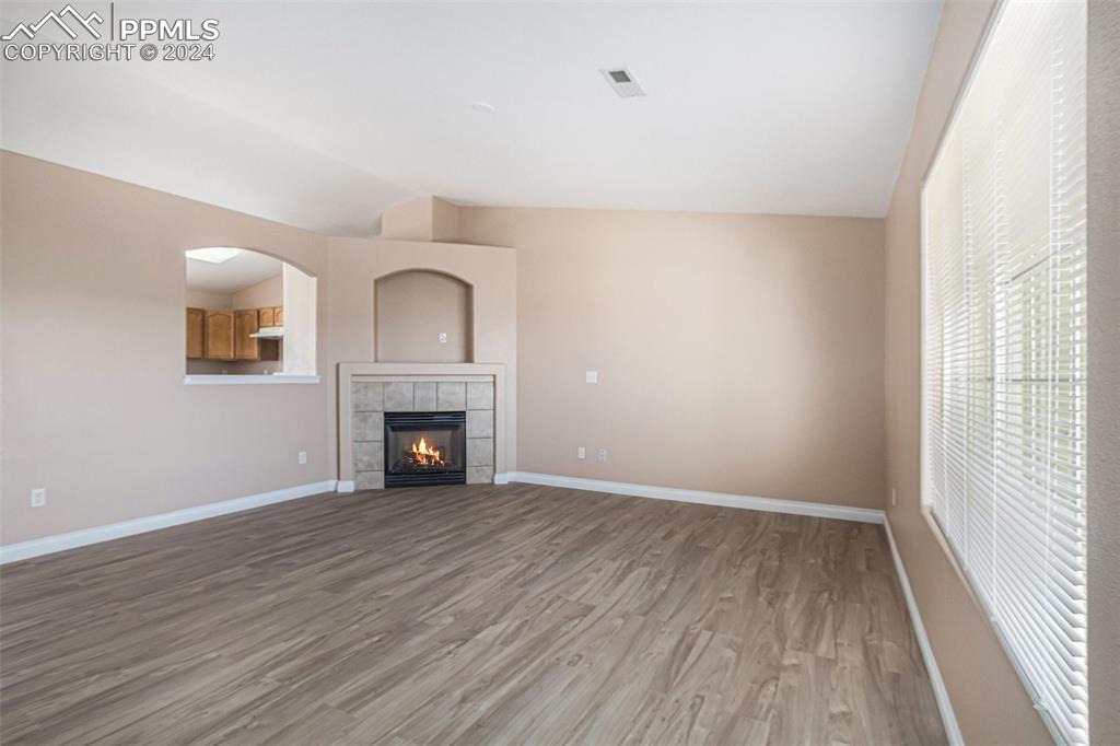4822 Rusty Nail Point, Unit 201 Colorado Springs, CO 80916 - Photo 5 of 33 wooden floor fireplace and windows in an empty room