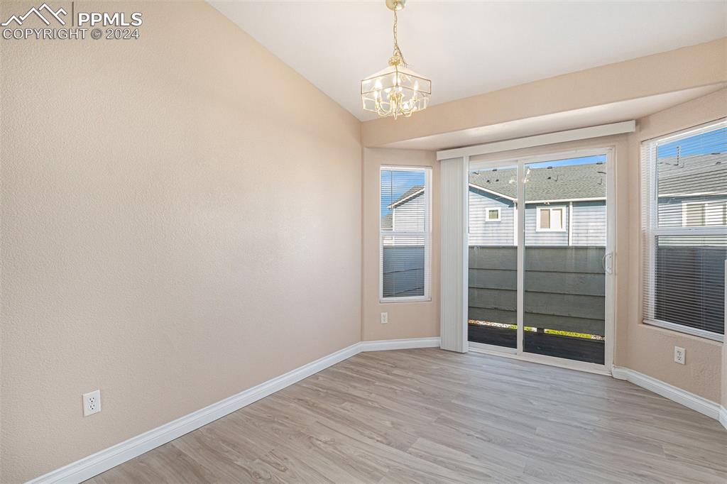 4822 Rusty Nail Point, Unit 201 Colorado Springs, CO 80916 - Photo 8 of 33 en empty room with wooden floor and exposed radiator