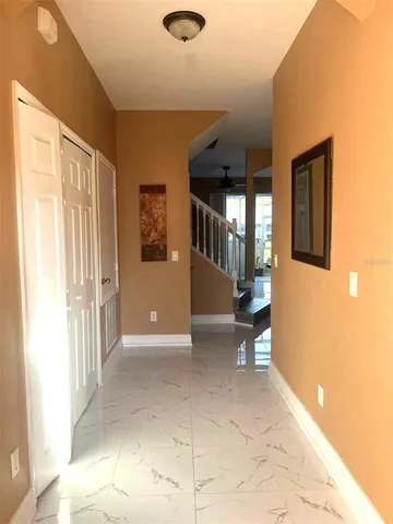 a view of a hallway with bathroom and a shower
