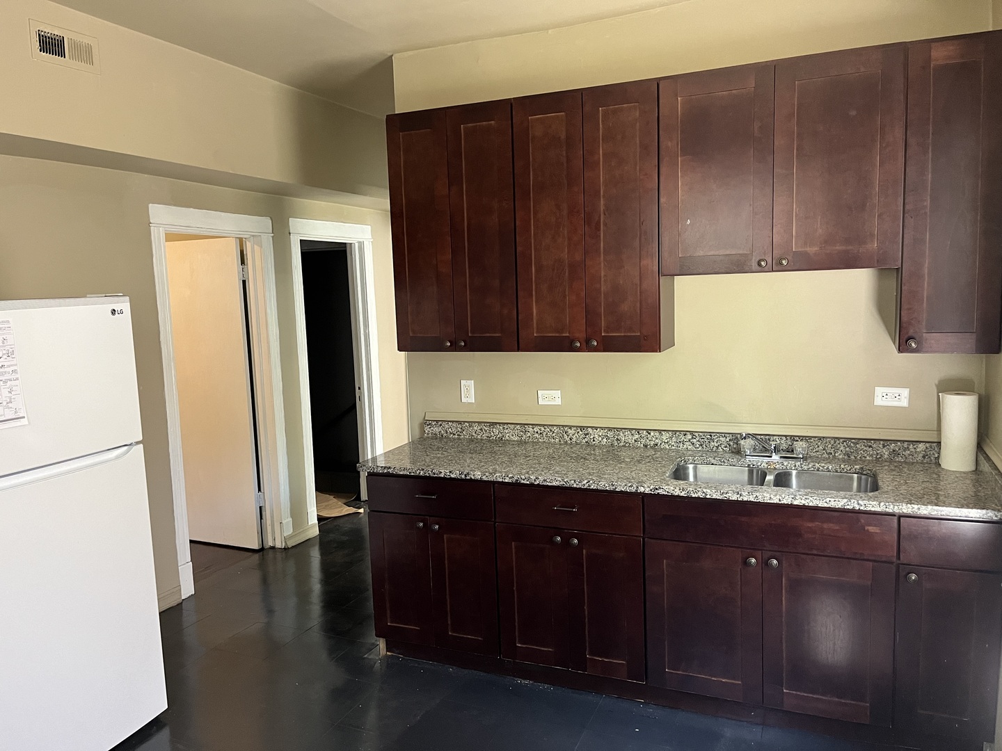 6916 South Lowe Avenue Chicago, IL 60621 - Photo 6 of 22 a kitchen with granite countertop wooden cabinets a sink a refrigerator and a stove