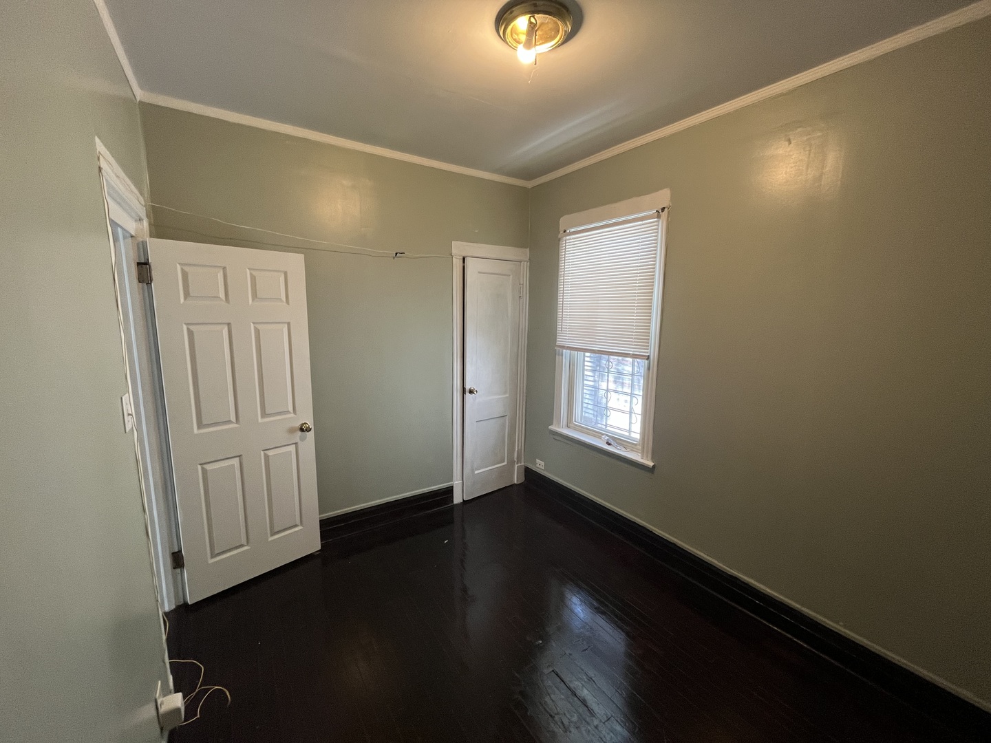 6916 South Lowe Avenue Chicago, IL 60621 - Photo 9 of 22 an empty room with wooden floor and windows