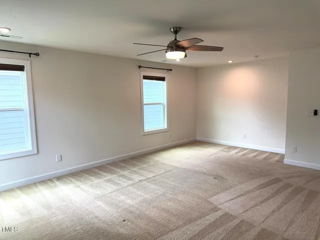 an empty room with a window and a fan