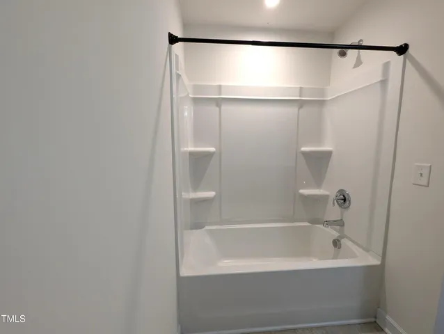 a bathroom with a white bath tub and a shower