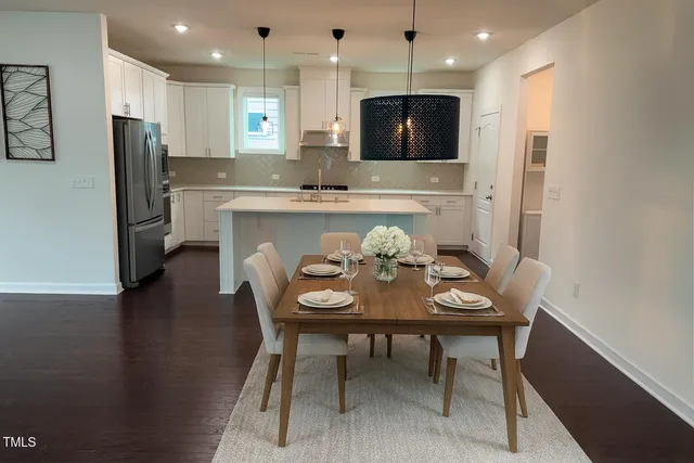 a kitchen with a table chairs refrigerator and microwave