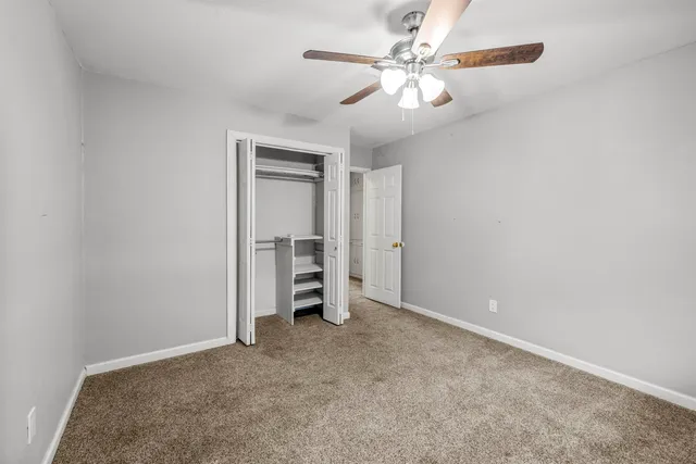 a view of an empty room with a ceiling fan