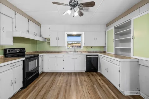 a kitchen with a sink window and cabinets