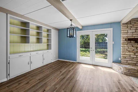 an empty room with windows and fan