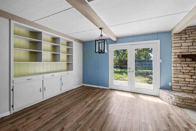 an empty room with windows and fan