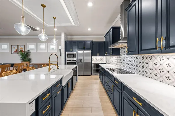 a large kitchen with a large counter space a sink and chandelier