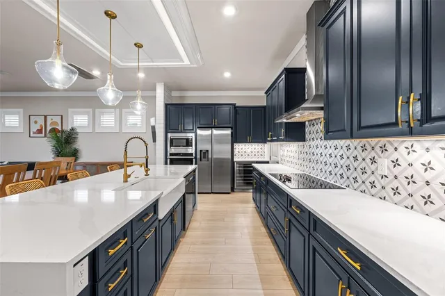 a large kitchen with a large counter space a sink and chandelier