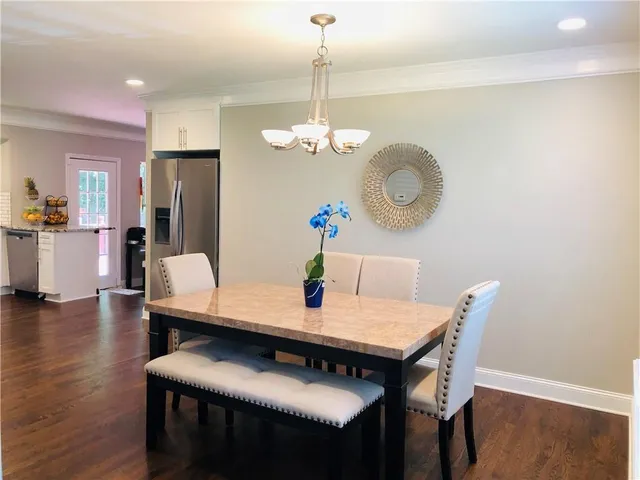 a view of a dining room with furniture a chandelier and wooden floor