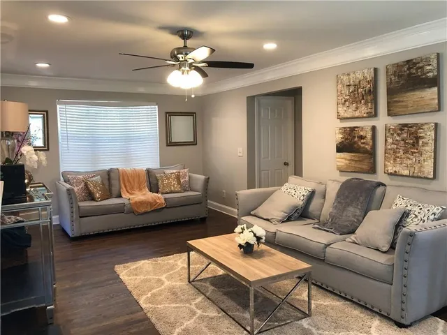 a living room with furniture and a ceiling fan