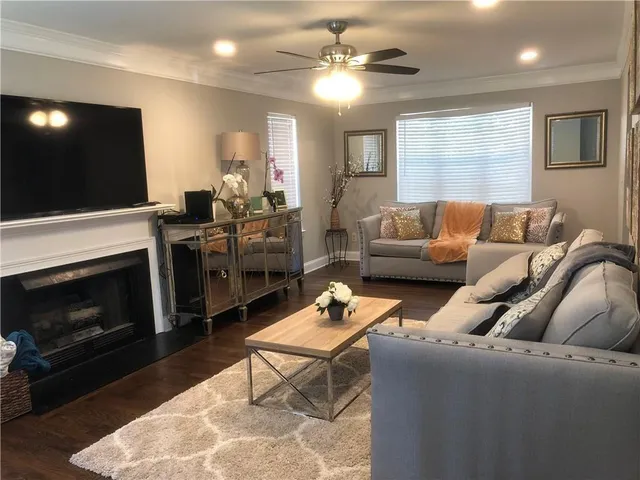 a living room with furniture a fireplace and a flat screen tv