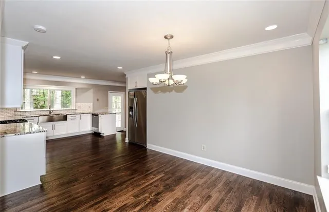 a view of a livingroom with a furniture wooden floor and chandelier