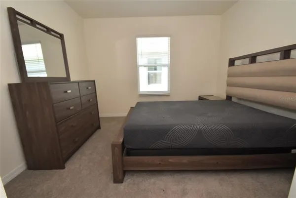 a bedroom with a bed and a mirror
