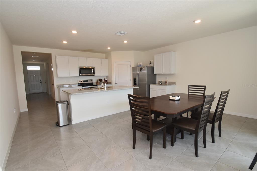 17918 Canopy Place Bradenton, FL 34211 - Photo 3 of 15 a kitchen with stainless steel appliances kitchen island granite countertop a table chairs and a refrigerator