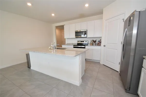 a kitchen with stainless steel appliances a refrigerator sink and stove