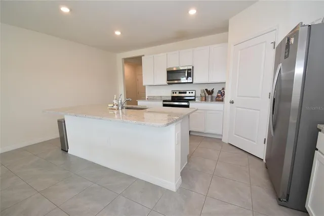 a kitchen with stainless steel appliances a refrigerator sink and stove