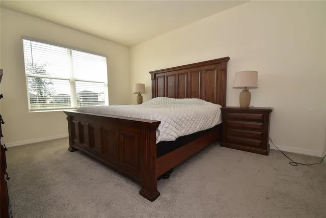 a bed sitting in a bedroom next to a window