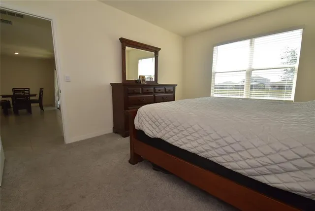 a bed sitting in a bedroom next to a window