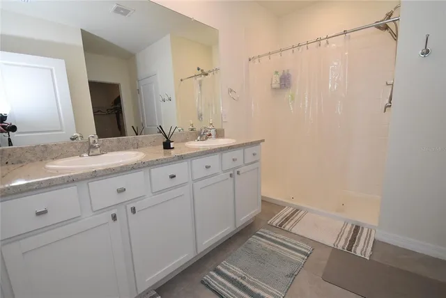 a bathroom with a double vanity sink and mirror