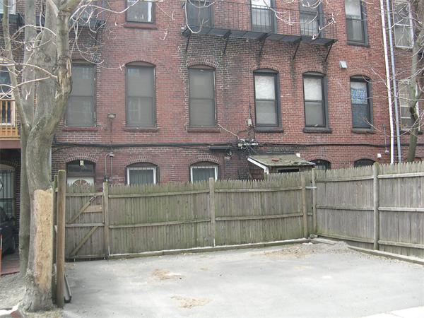 9 Symphony Road Boston, MA 02115 - Photo 6 of 9 a view of a brick house with large windows and a wooden fence
